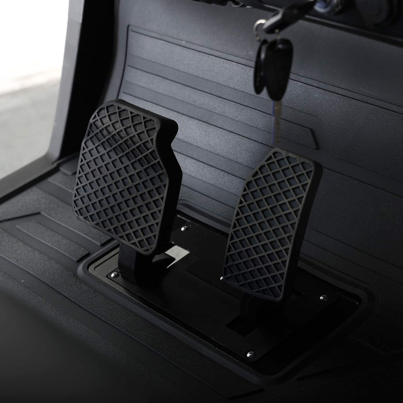 Close-up of the accelerator and brake pedals inside the Bintelli ActivEV Pulse golf cart.