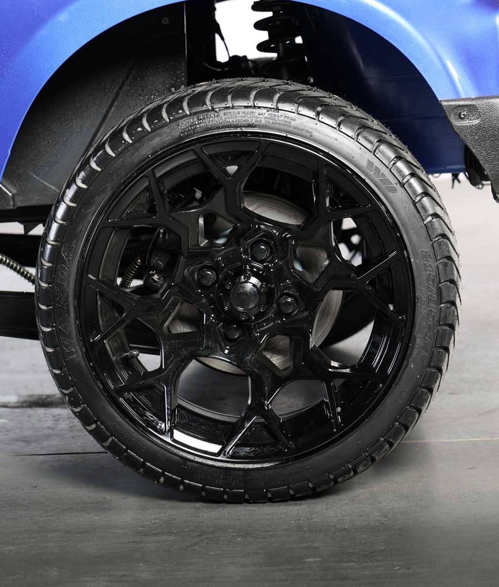 Close-up of the 14-inch black rim and tire on the Bintelli ActivEV Pulse golf cart.