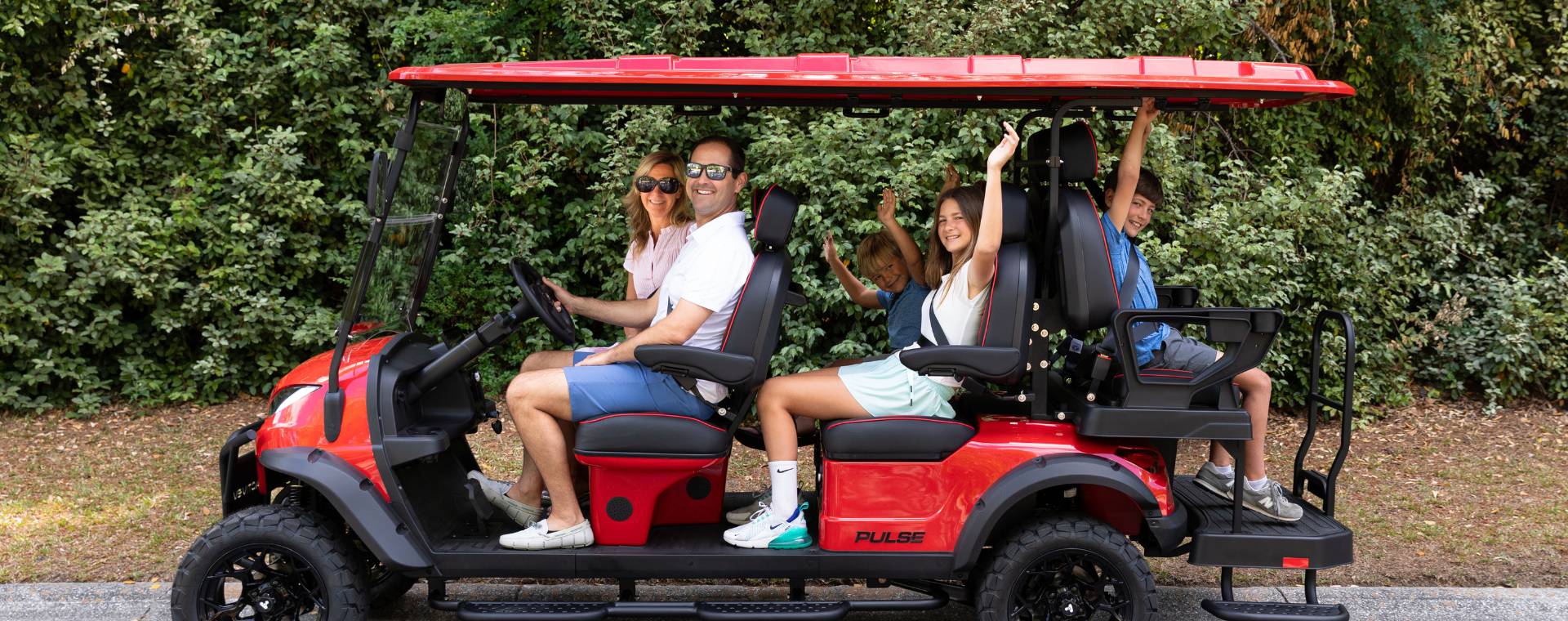 Family riding together in a six-seater Bintelli ActivEV Pulse golf cart.