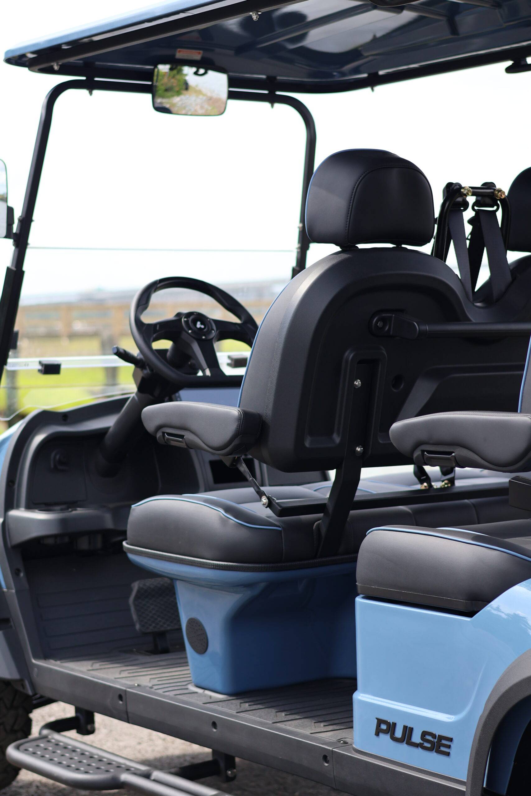 Blue Back Bay Rentals six-seater golf cart parked beside the water at an angle.