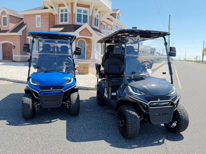 Blue Back Bay Rentals four-seater golf cart viewed from the front corner near the bay.