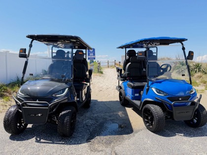 Front view of the blue Back Bay Rentals golf cart at a sandy beach access point.